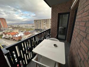 a white table on a balcony with a view of a city at 4-YOU Apartment in Ferizaj