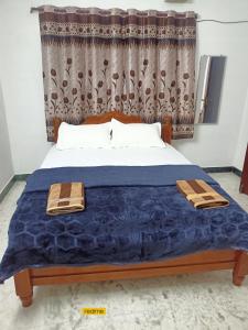 a bedroom with a bed with a blue comforter at LA villa Rani in Madurai
