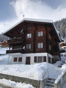 a large wooden building with snow on the ground at Ferienwohnung im Chalet Boubou in Wiler