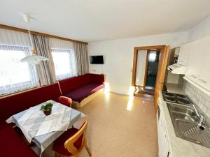 a living room with a red couch and a table at Haus Luxer in Auffach