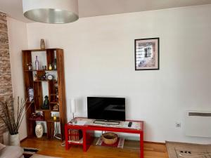 a living room with a red table and a television at Apartman Pale in Pale