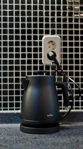 a black tea kettle sitting on a counter next to an outlet at Serene Space Seoul in Seoul