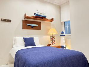 Un dormitorio con una cama azul y blanca y una ventana en Magnifico Alojamiento Con Encanto En El Centro, en Santander
