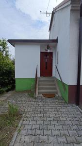 a building with a red door and a brick walkway at Dom na szlaku Krakowskim in Łączany