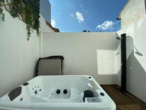 a bath tub sitting on the side of a white wall at Moradia com jaccuzzi e sky view in Bombarral