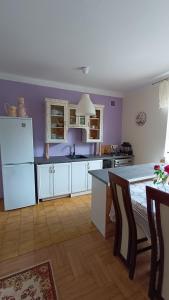 a kitchen with purple walls and a white refrigerator at Dom na szlaku Krakowskim in Łączany