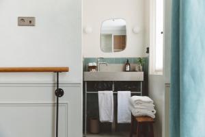 a bathroom with a sink and a mirror and towels at HOY Paris - Yoga Hotel in Paris