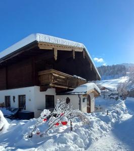 湖畔捷爾的住宿－Ferienhaus Sommerbichl，前面的地面上积雪的建筑