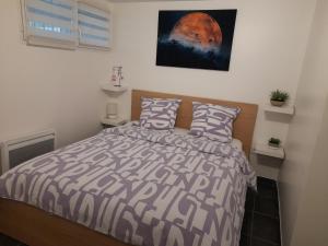 - une chambre avec un lit et une photo sur le mur dans l'établissement Appartement proche d'Orly, à Villeneuve-le-Roi