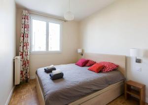 ein Schlafzimmer mit einem großen Bett mit roten Kissen in der Unterkunft 10 mns from Champs-Elysées, quiet in Paris