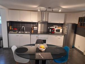 une cuisine avec une table et des chaises dans l'établissement Appartement proche d'Orly, à Villeneuve-le-Roi