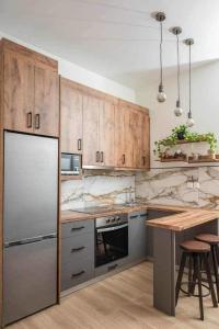 a kitchen with stainless steel appliances and wooden cabinets at Flat in Athens next to Metro st! in Athens