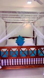 a bedroom with a wooden bed with a canopy at Mirissa Royal Ace in Mirissa