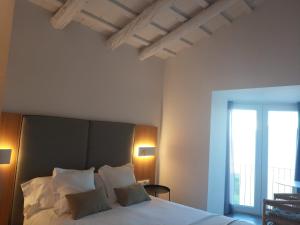 Schlafzimmer mit einem Bett mit weißer Bettwäsche und einem Fenster in der Unterkunft MAS CATXINA Hotel Boutique 4 estrellas in Deltebre
