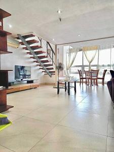 a living room with a staircase and a table and chairs at Cubic P 1902 in Cebu City