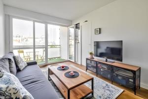 - un salon avec un canapé et une télévision dans l'établissement Soleil du canal Saint Martin, à Paris