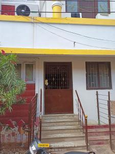 een huis met een bruine deur en een trap voor de deur bij LA villa Rani in Madurai