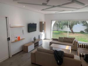 een woonkamer met 2 banken en een tv bij Villa 8 personnes Hammamet Zone Plage et Hotels in Hammamet