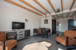 a living room with a television and a table at Christinahoeve Logies in Boskoop