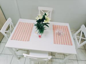 a white table with a vase of flowers on it at Mary cozy house in Athens