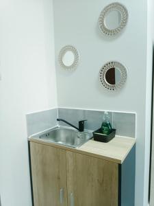 a kitchen sink with two mirrors on the wall at Mary cozy house in Athens