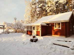 ein kleines Haus mit Schnee in einem Hof in der Unterkunft Punatulkku in Kalajoki