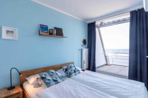 Un dormitorio con una cama y una ventana grande en Ferienwohnung Pier 1167, en Schilksee