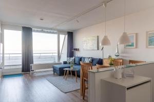 Una sala de estar con un sofá azul y una mesa. en Ferienwohnung Pier 1167, en Schilksee