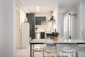 a kitchen with a table and chairs and a refrigerator at Tetuán Apartments, by Homing U in Seville