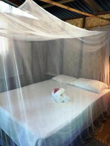 łóżko w namiocie z dwoma składanymi ręcznikami w obiekcie YbYmara Eco Glamping w mieście Serra Grande