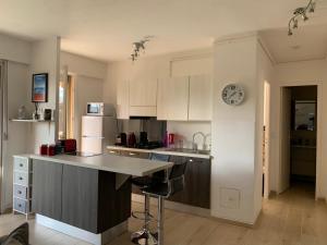 a kitchen with a counter and a clock on the wall at Agréable 2 pièces à 150 m de la mer in Cagnes-sur-Mer