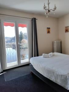 Peyrat-le-ChâteauにあるLe Belleriveのベッドルーム1室(ベッド1台、大きな窓付)