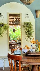 a dining room with a table and a mirror at Vila Pitanga Trancoso in Trancoso