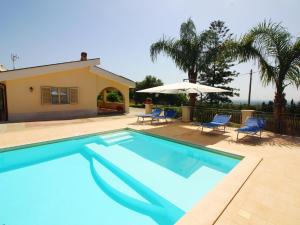 einen Pool mit 2 Stühlen und einem Sonnenschirm in der Unterkunft Holiday home in Floridia with private pool in Solarino