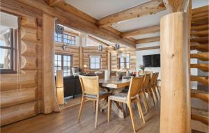 ein Esszimmer und eine Küche in einem Blockhaus mit einem Tisch und Stühlen in der Unterkunft Stunning Home In Nimtofte With Kitchen in Nimtofte