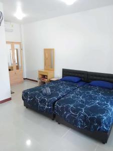 um quarto com uma cama com um edredão azul em Thaineth Sport Camp em Nong Prue