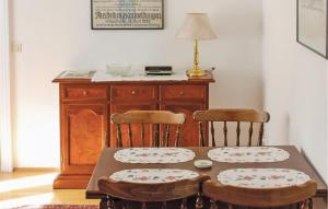 a dining room table with two chairs and a wooden cabinet at Apartment Marktplatz in Perchtoldsdorf
