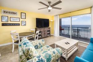 een woonkamer met een bank en een tafel met een televisie bij Pelican Isle 406 in Fort Walton Beach