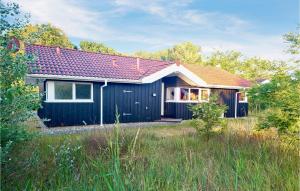 ein kleines schwarzes Haus mit rotem Dach in der Unterkunft Strandblick 11 - Dorf 1 in Travemünde