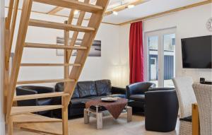 a living room with a staircase and a couch and chairs at Ferienhaus 2 Altefhr in Altefähr