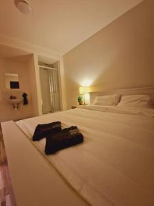 - un lit blanc avec 2 serviettes noires dans l'établissement Private room 202 - Eindhoven - By T&S., à Eindhoven