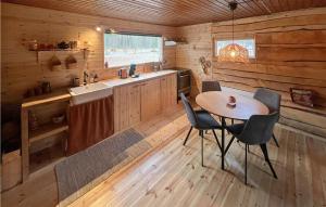 a kitchen with a table and chairs in a cabin at Gorgeous Home In Grsmark With Wifi in Gräsmark