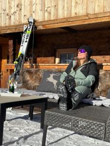 a woman sitting on a bench with her skis on a table at Ferienwohnung Kast'l in Alpbach