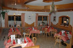 a restaurant with tables and chairs with red napkins on them at Hotel Hörlgut in Maria Alm am Steinernen Meer