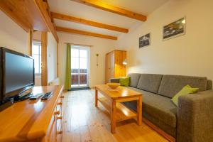 a living room with a couch and a table at Penzion Sokolovna in Kořenov