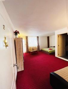プレデアルにあるPredeal Clubの赤いカーペット敷きの部屋、ベッドルーム1室