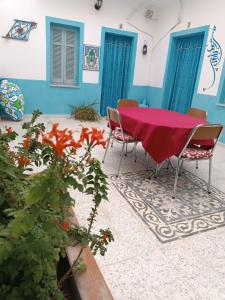 a table with chairs and a red table cloth on a patio at Dar Hkaïem in Hammam Sousse