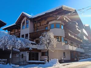 een gebouw met sneeuw op de grond ervoor bij Tramberger Apartments in Reith im Alpbachtal