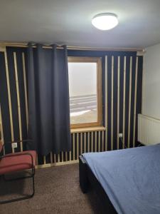 a bedroom with a bed and a window with stripes at Cabana Rosie in Vartop +3 photos