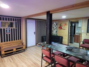 a living room with a glass table and chairs at Cabana Rosie in Vartop